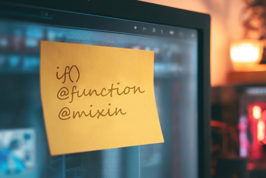 Datorskärm med postit-lapp där det står en handskriven kodsnutt skriven. Det står, if() @function @mixin