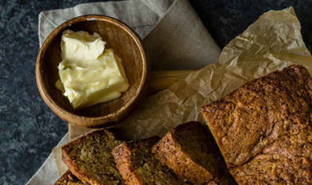 Cut up loaf of bread with a jar of butter on the side.