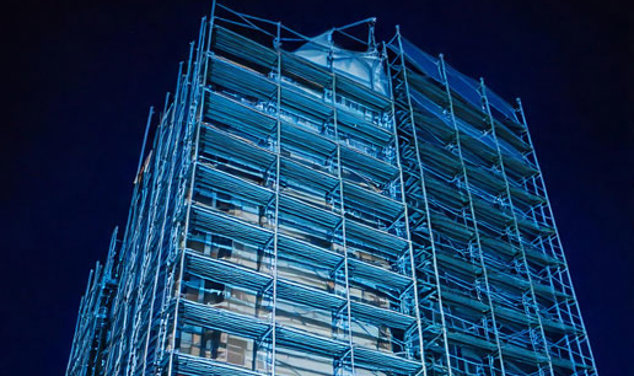 Scaffolding outside a high-rise, in the dark at night